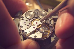 Working On A Mechanical Watch. A watch makers work top. The inside workings of a vintage mechanical watch.